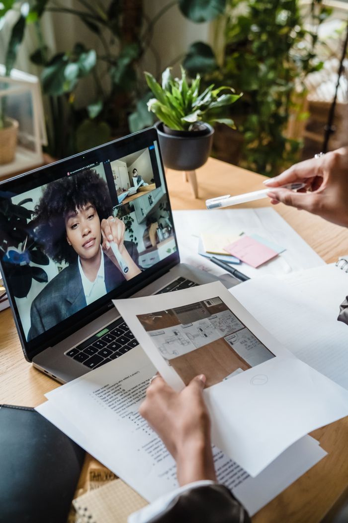 Mastering the First Impression: Your intriguing post title goes here Businesswoman engaging in a remote work video call with documents on laptop.