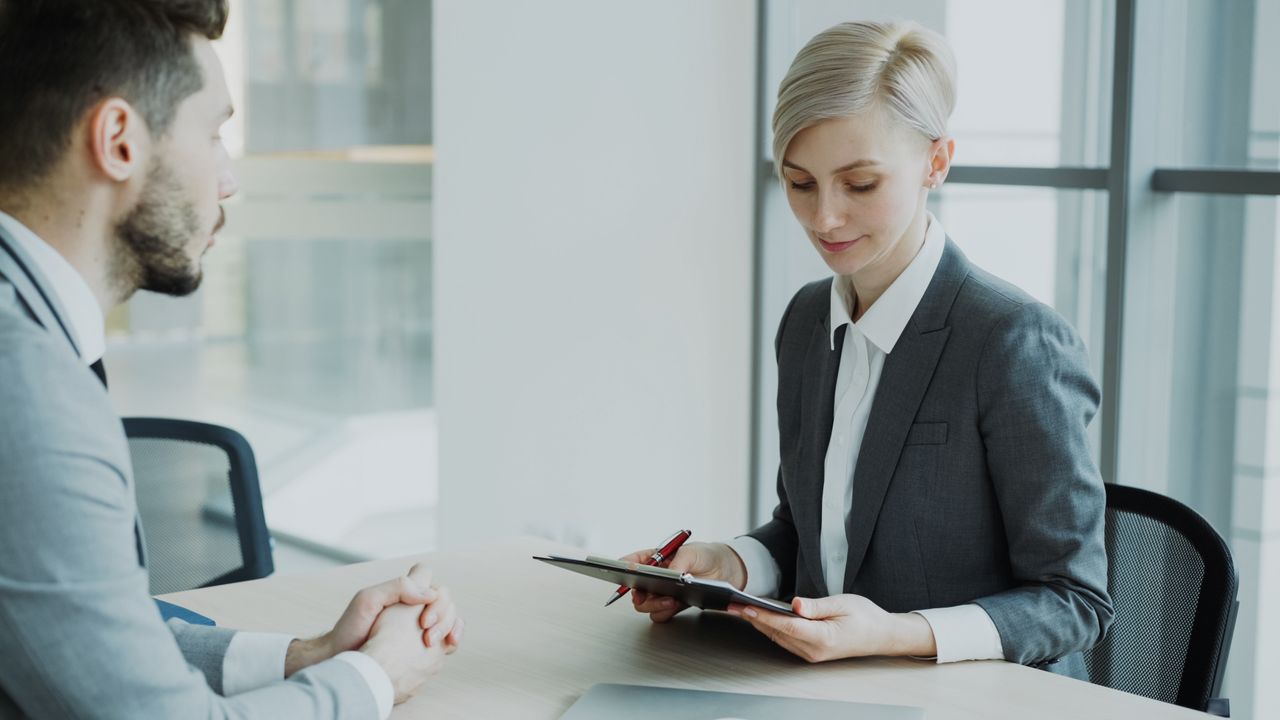 About Two professionals in a modern office discussing business. Bright, professional setting.