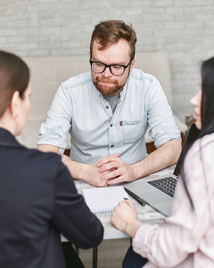 Crafting Captivating Headlines: Your awesome post title goes here Professional business meeting with a bearded man and two colleagues in an office setting.